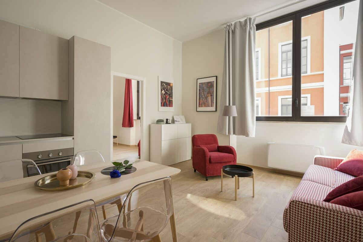 Perde të larta dhe divan në apartament
